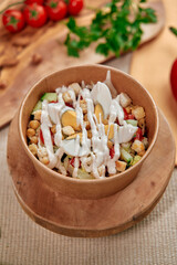 Delicious and Fresh Salad in a Wooden Bowl with Creamy Dressing Garnished with Nuts and Vegetables Ready to Savor