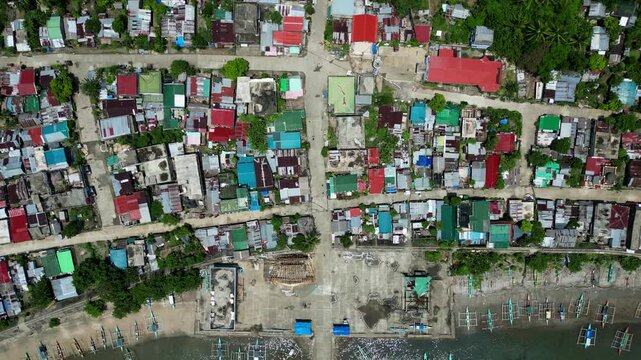 Top-Down Aerial Drone Shot of Colorful Coastal Barangay Layout with rooftops and boat docks in Codon, San Andres, Catanduanes, Philippines