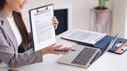 Asian professional adult woman insurance agent presents vital policy document advises client on financial security planning