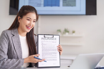 Asian adult woman insurance agent explains policy terms during a business meeting for client...