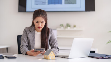 Adult Asian woman calculates property investment mortgage finance home costs real estate market analysis