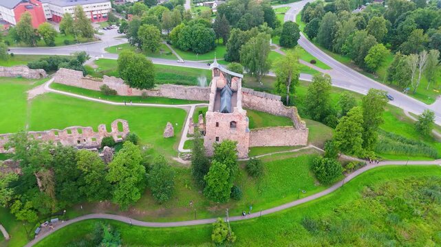 Aerial View of Dobele Castle Ruins, Flowing Berze River and Illuminated Fountains at Sunset Serene Latvian Summer Evening from Above, Scenic Aerial of Latvian Historical Landscape in Golden Hour