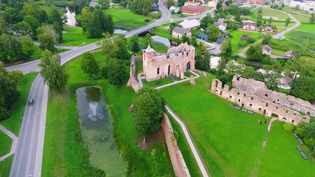 Aerial View of Dobele Castle Ruins, Flowing Berze River and Illuminated Fountains at Sunset Serene Latvian Summer Evening from Above, Scenic Aerial of Latvian Historical Landscape in Golden Hour
