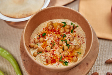 Deliciously Creamy Chickpea Dip Topped with Spices and Ingredients Served in a Rustic Bowl...