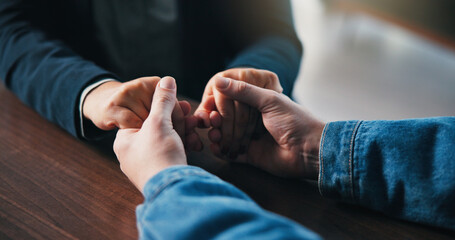 Holding hands, table and couple in home for support, empathy and bonding for love. Relationship, counseling and above of people together for connection, affection and care for commitment in house
