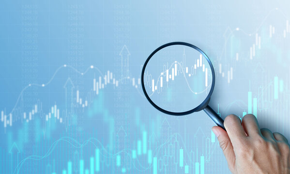 Hand holding magnifying glass analyzing digital financial stock chart. Data analysis, investment research, trading strategy, and financial market concept on blue background. business stock market.
