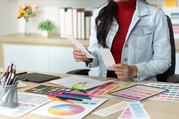 Designer Reviewing Color Samples and Sketches in Office