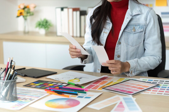 Designer Reviewing Color Samples and Sketches in Office - Powered by Adobe