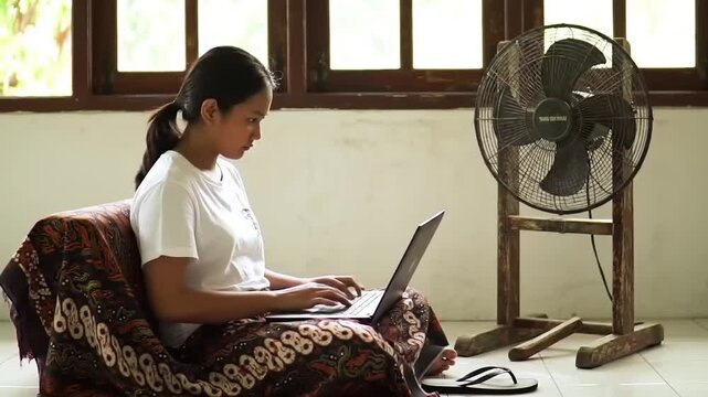 Young woman using laptop indoors