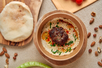 Delicious Bowl of Hummus Topped with Flavorful Meatball and Surrounded by Fresh Ingredients for a Delightful Culinary Experience