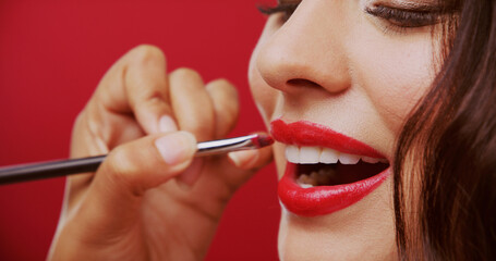 Woman, brush and lipstick for beauty in studio with makeup, facial makeover and foundation glow....