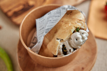 Delicious Wrap Filled with Spiced Chicken, Fresh Vegetables, and Creamy Sauce Served in a Natural Wooden Bowl for a Tasty Culinary Experience