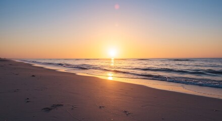 Fototapeta premium 穏やかな朝焼けが美しい砂浜の風景、静かに波が寄せる海岸線