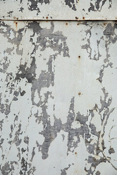 Weathered wall shows signs of age with peeling paint, and texture creates an abstract background.