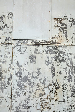 Weathered wall shows signs of age with peeling paint, and texture creates an abstract background.