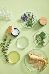 Assorted natural ingredients including ginseng, aloe, green herbs, and essential oils displayed in circular petri dishes. Bright flatlay setup for cosmetic testing or product development.