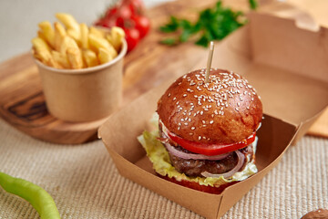 Delicious Gourmet Burger Served with Crispy French Fries and Fresh Vegetables in a Cozy Casual Dining Environment