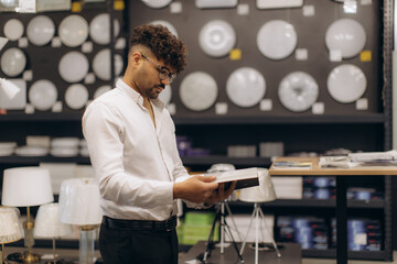 Man Shopping in a Lighting Store Examining Product Specifications