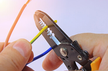 Hand holding electrical tools to assemble the electrical control panel. 