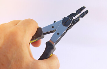 Hand holding electrical tools to assemble the electrical control panel. 