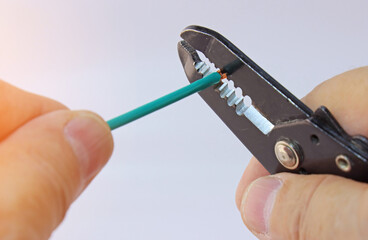 Hand holding electrical tools to assemble the electrical control panel. 