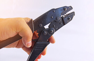 Hand holding electrical tools to assemble the electrical control panel. 