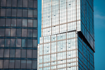 mirrored windows of the facade of an office building with blue panels