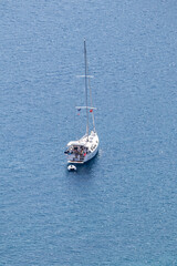 White sailboat in the blue sea or ocean. Schooner in Marmaris Mugla. Watercraft concept. Boat holiday or trip. Travel. Top view, above. Copy space, blank. Vertical photo.