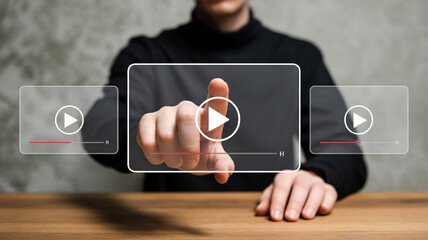 Person's finger pressing a play button on a video interface media entertainment