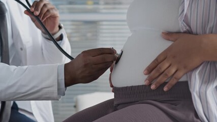 Cropped closeup of physician conducting routine prenatal exam, listening to fetal heartbeat of pregnant woman to monitor baby health and development - Powered by Adobe