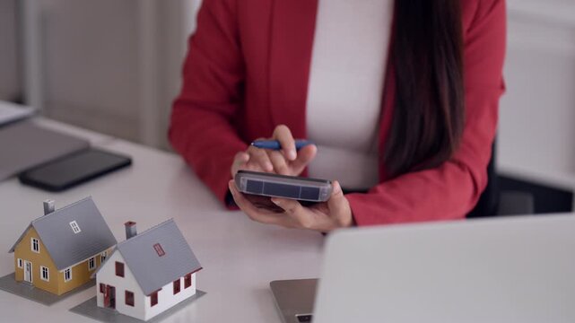 Asian adult real estate professional calculates property cost insurance investment mortgage financial strategy office desk setting