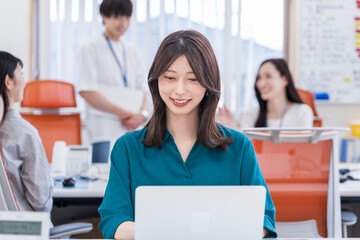 オフィスで働く若い女性。
