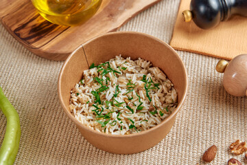 Delicious Bowl of Flavored Rice Topped with Chopped Herbs and Nuts Set Against a Rustic Background of Olive Oil and Spices