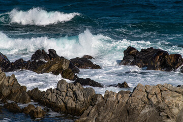 idyllic seascape with rocky beach and breaking waves