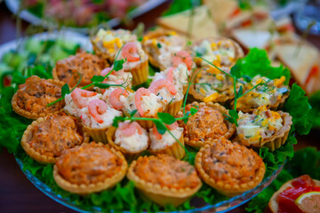 Delicious assortment of savory tarts and appetizers displayed on a platter at a festive gathering