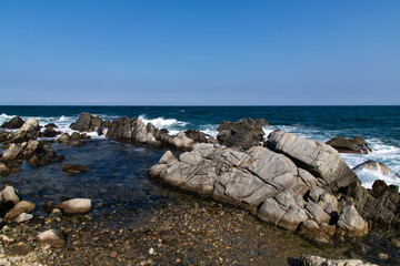 idyllic seascape with rocky beach and breaking waves