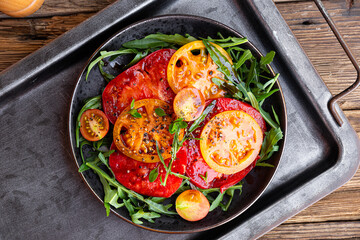 Simple Italian Salad with Tomatoes and Arugula on wooden background top view, Italian Food