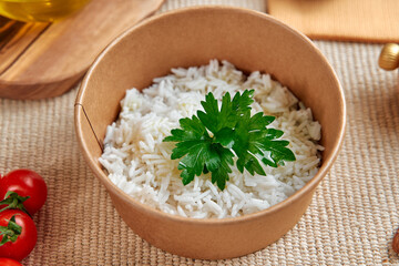 Deliciously Fresh Cooked Rice Served in a Natural Brown Bowl Garnished with a Sprig of Parsley and...