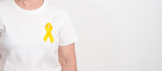 Elderly with Yellow Ribbon for concept of yellow September, Suicide prevention day, Childhood, July Sarcoma, bone and bladder cancer Awareness month, support survivor. Healthcare and World Cancer day
