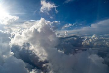 Fototapeta premium Dramatic sky with sunbeams and clouds seen from an airplane