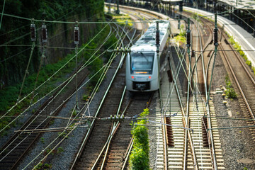Fototapeta premium Oberleitungen und Gleise mit Zug am Bahnhof in Wuppertal, Deutschland