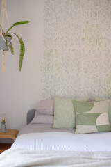 a queen bed made up with green cushions