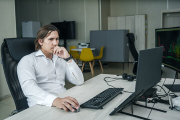 Man working at his computer in a modern office space.