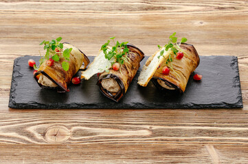 stuffed eggplant rolls on black board