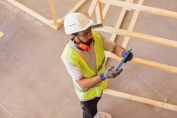 worker with helmet and safety jacket working in a hall