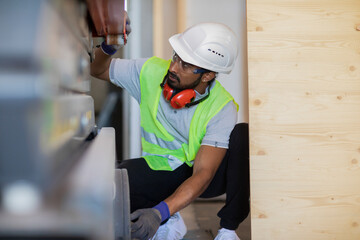 worker with helmet and safety jacket working in a wooden hall