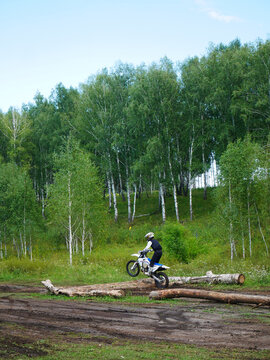 Dirt Bike Challenge: Rider Conquers Logs on Off-Road Track