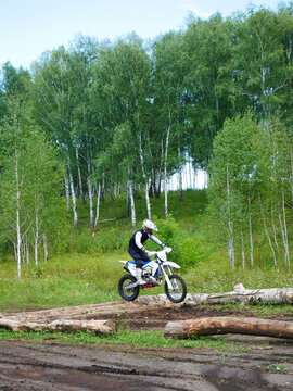 Dirt Bike Challenge: Rider Conquers Logs on Off-Road Track
