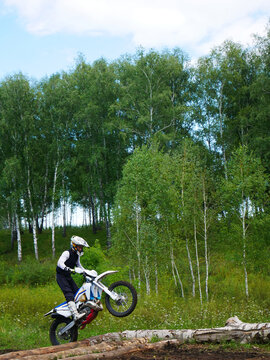 Dirt Bike Challenge: Rider Conquers Logs on Off-Road Track