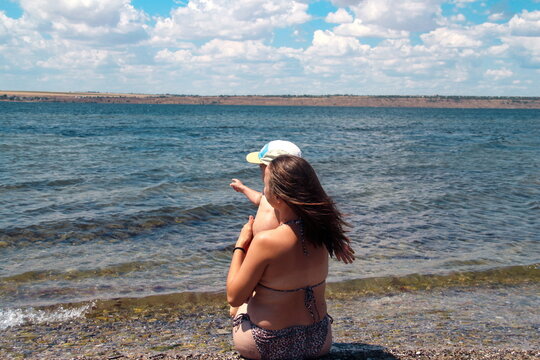 Mother and child looking at the sea horizon
